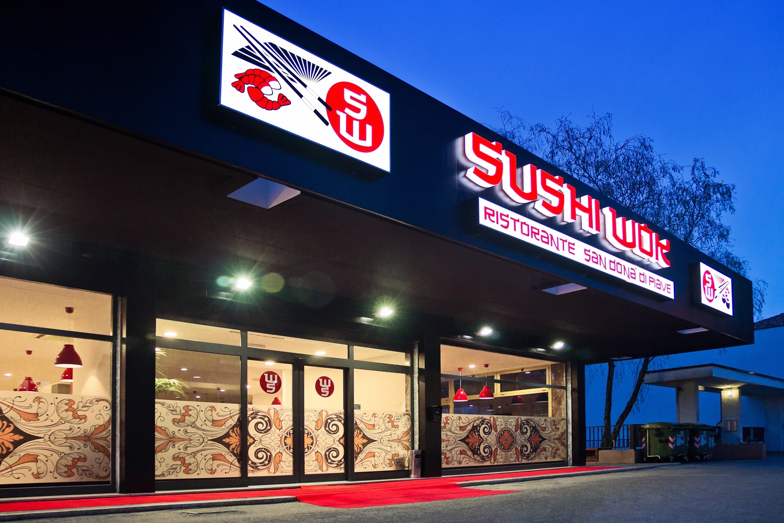 Facciata illuminata Sushi Wok, insegna e allestimento ingresso